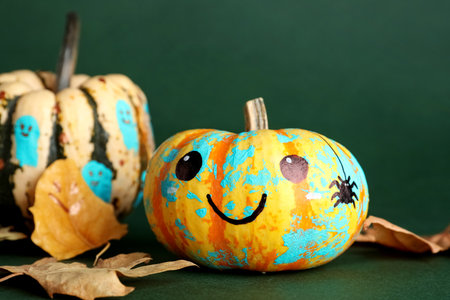 Halloween pumpkins and autumn leaves on green background, closeupの写真素材