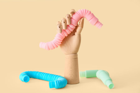 Wooden hand with Pop Tube on yellow background