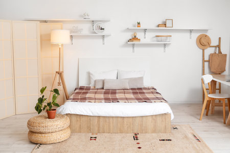 Interior of light bedroom with folding screen and glowing lampの写真素材