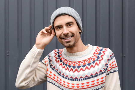 Handsome young man in knitted sweater outdoors