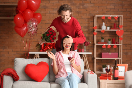 Man greeting his girlfriend on Valentine's Day at homeの写真素材