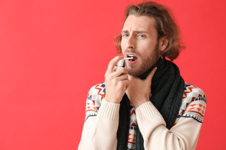 Ill man with inhaler on color backgroundの写真素材