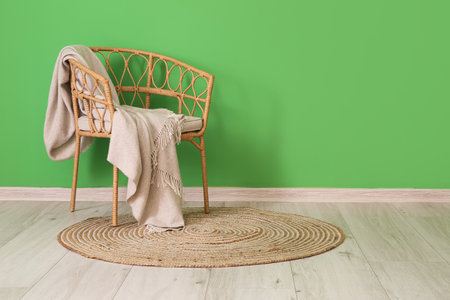 Chair with plaid and stylish wicker carpet in room interiorの写真素材