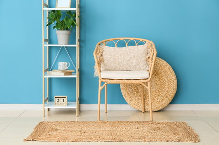 Interior of room with wicker chair, shelf unit and stylish carpetの写真素材