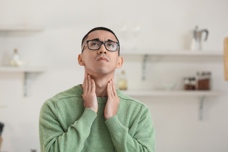 Ill Asian man with sore throat at home
