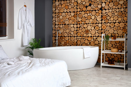 Stylish interior of bedroom with bathtubの写真素材