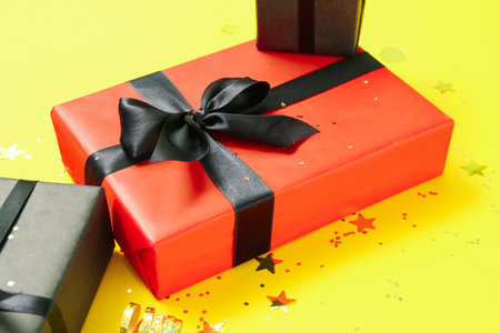 Gift box on yellow background, closeup. black friday sale