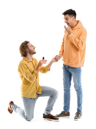 Young gay proposing to his boyfriend on white backgroundの写真素材