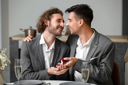Young gay proposing to his boyfriend on romantic dateの写真素材
