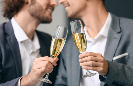 Happy gay couple drinking champagne on romantic dateの写真素材