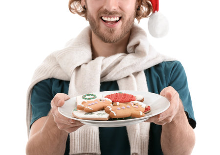 Young man holding plate with gingerbread cookies on white background, closeupの写真素材