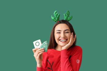 Happy young woman with gingerbread cookies on green backgroundの写真素材