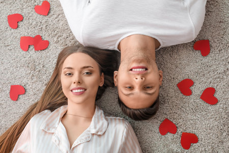 Happy couple lying on floor at home, top view. Valentine's Day celebrationの写真素材