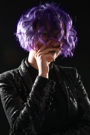 Beautiful young woman with violet hair on black background. Very Peri - color of year 2022の写真素材