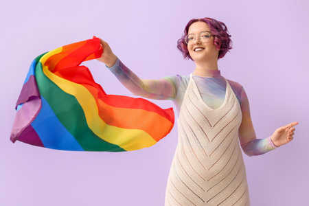 Portrait of young woman with LGBT flag on color backgroundの写真素材