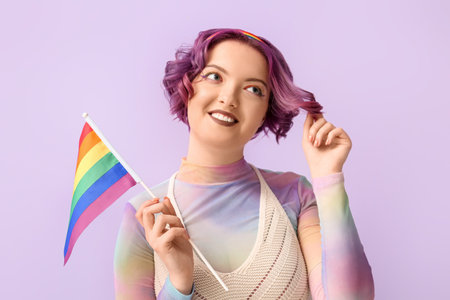 Portrait of young woman with LGBT flag on color background