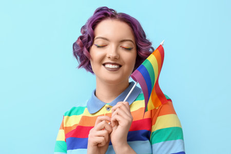 Young woman with LGBT flag on blue backgroundの写真素材