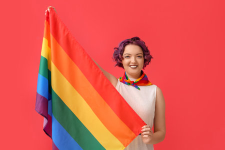 Young woman with LGBT flag on red backgroundの写真素材