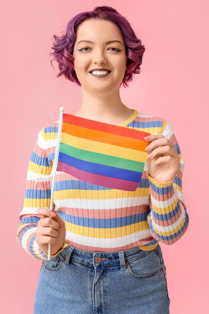 Young woman with LGBT flag on pink background