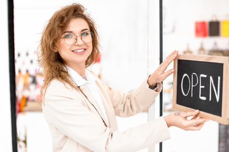 Young female business owner opening her shop