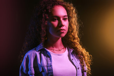 Toned portrait of beautiful young woman on black backgroundの写真素材