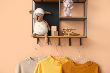 Shelf with toys and sweaters on color backgroundの写真素材