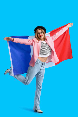 Beautiful happy young woman with flag of France on blue backgroundの写真素材