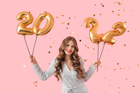 Beautiful young woman with balloons in shape of figure 2022 on color background. new year...