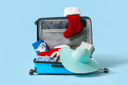 Open suitcase with Christmas socks and things on blue backgroundの写真素材