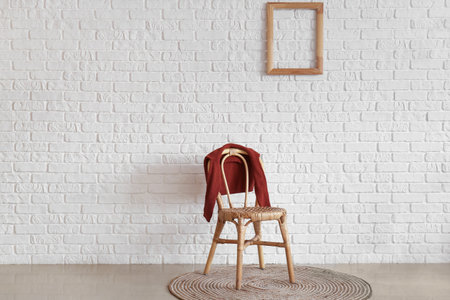 Children's sweater on chair near white brick wall in roomの写真素材