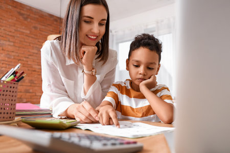 Little African-American boy studying Mathematics with tutor at homeの写真素材