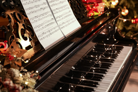Grand piano with note sheets decorated for Christmas in room, closeupの写真素材