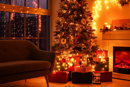 Stylish interior of living room with beautiful Christmas tree and fireplace in the eveningの写真素材