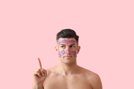 Handsome man with glitter mask on pink backgroundの写真素材