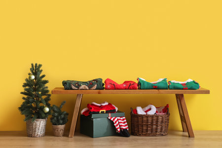 Bench with folded Christmas clothes in roomの写真素材