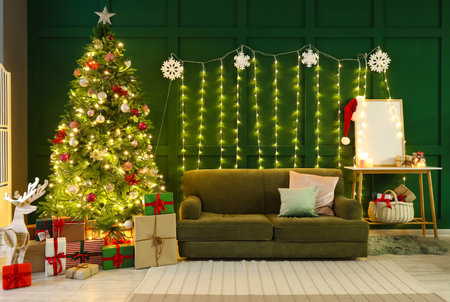 Interior of stylish living room with big Christmas tree, glowing lights and sofaの写真素材