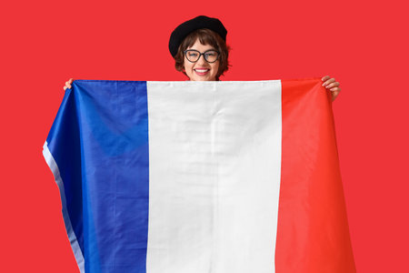 Young woman with flag of France on red backgroundの写真素材