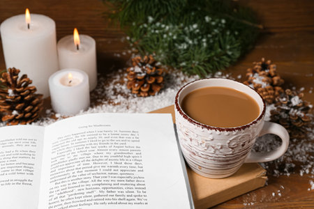 Cup of tasty coffee, book and Christmas decor on wooden backgroundの写真素材
