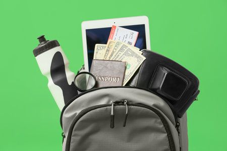 Packed backpack with travel accessories on color backgroundの写真素材