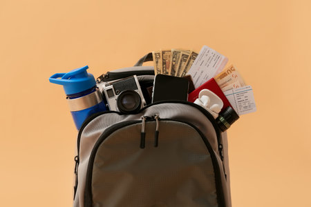 Packed backpack with travel accessories on color backgroundの写真素材