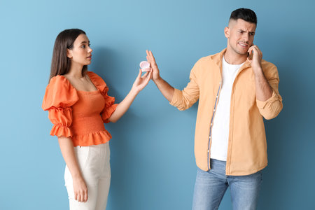 Busy young man rejecting marriage proposal on color backgroundの写真素材