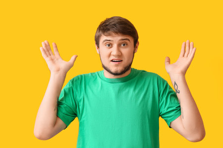 Shocked young man in green t-shirt on color backgroundの写真素材