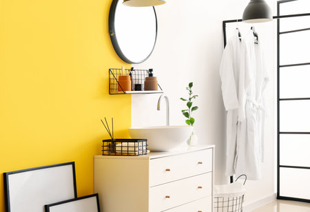 Interior of stylish bathroom with drawers, sink and mirrorの写真素材