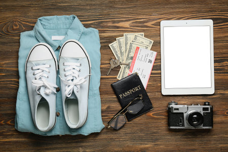 Guide's belongings with tablet computer and photo camera on wooden backgroundの写真素材