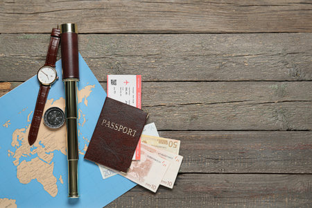 Guide's belongings with world map and passport on dark wooden backgroundの写真素材