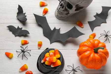 Halloween decor with candy corns on white wooden background