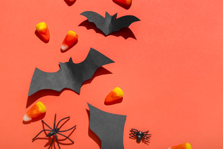 Paper bats with candy corns and spiders on red backgroundの写真素材