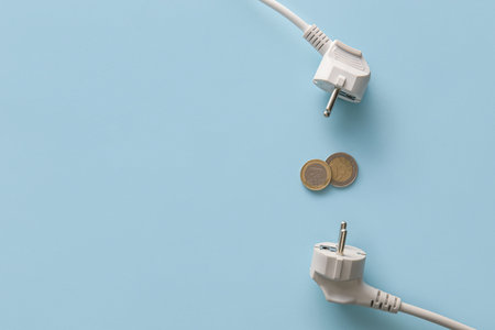 Coins with plugs on blue background. heating season conceptの写真素材