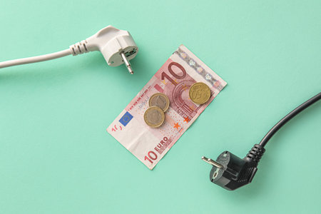 Money with plugs on green background. heating season conceptの写真素材