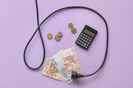 Money with plug and calculator on lilac background. heating season conceptの写真素材